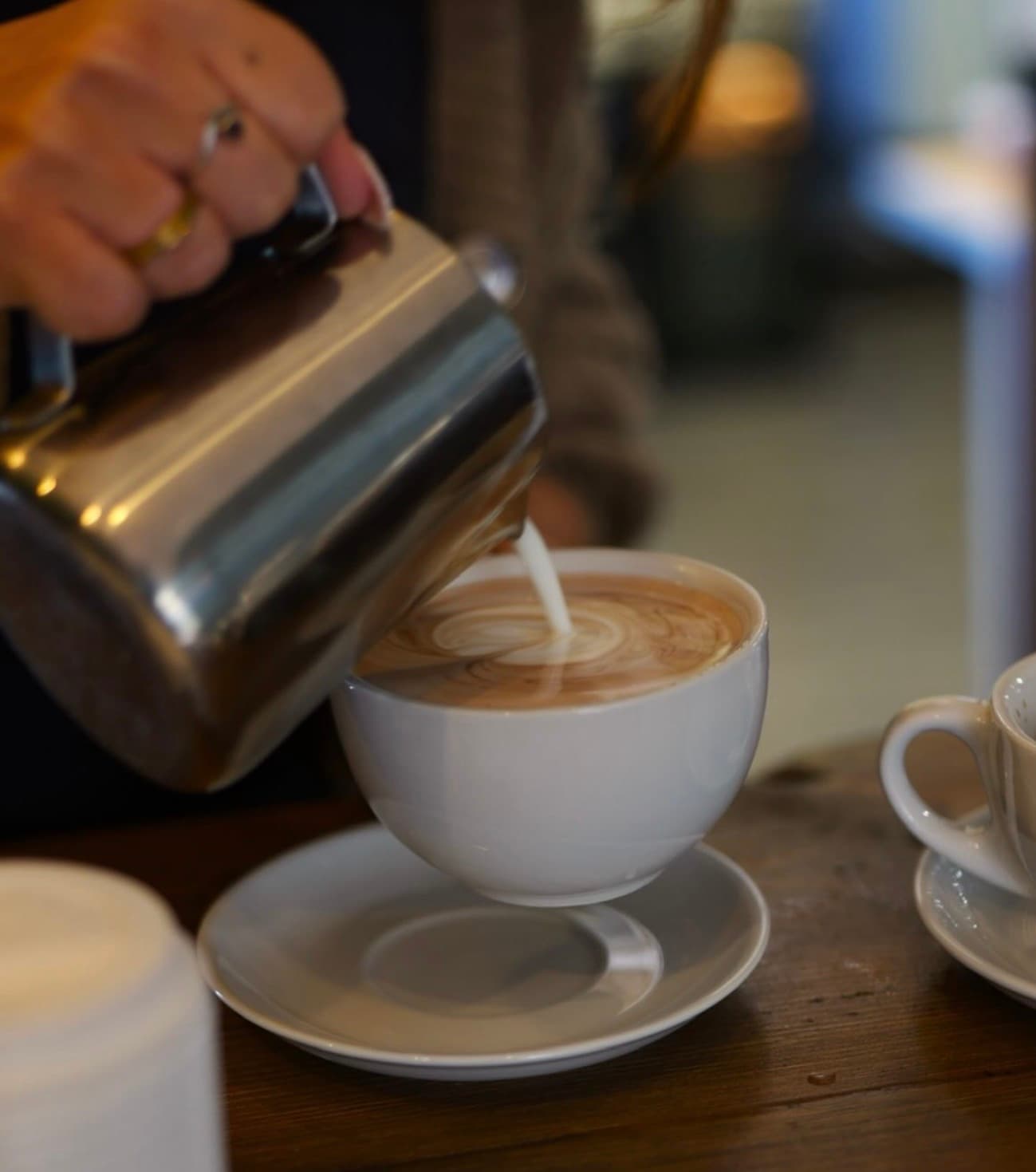 Milk being poured into a coffee for latte art