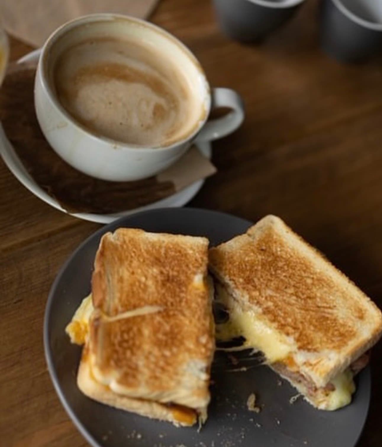 A toastie and a latte on the table